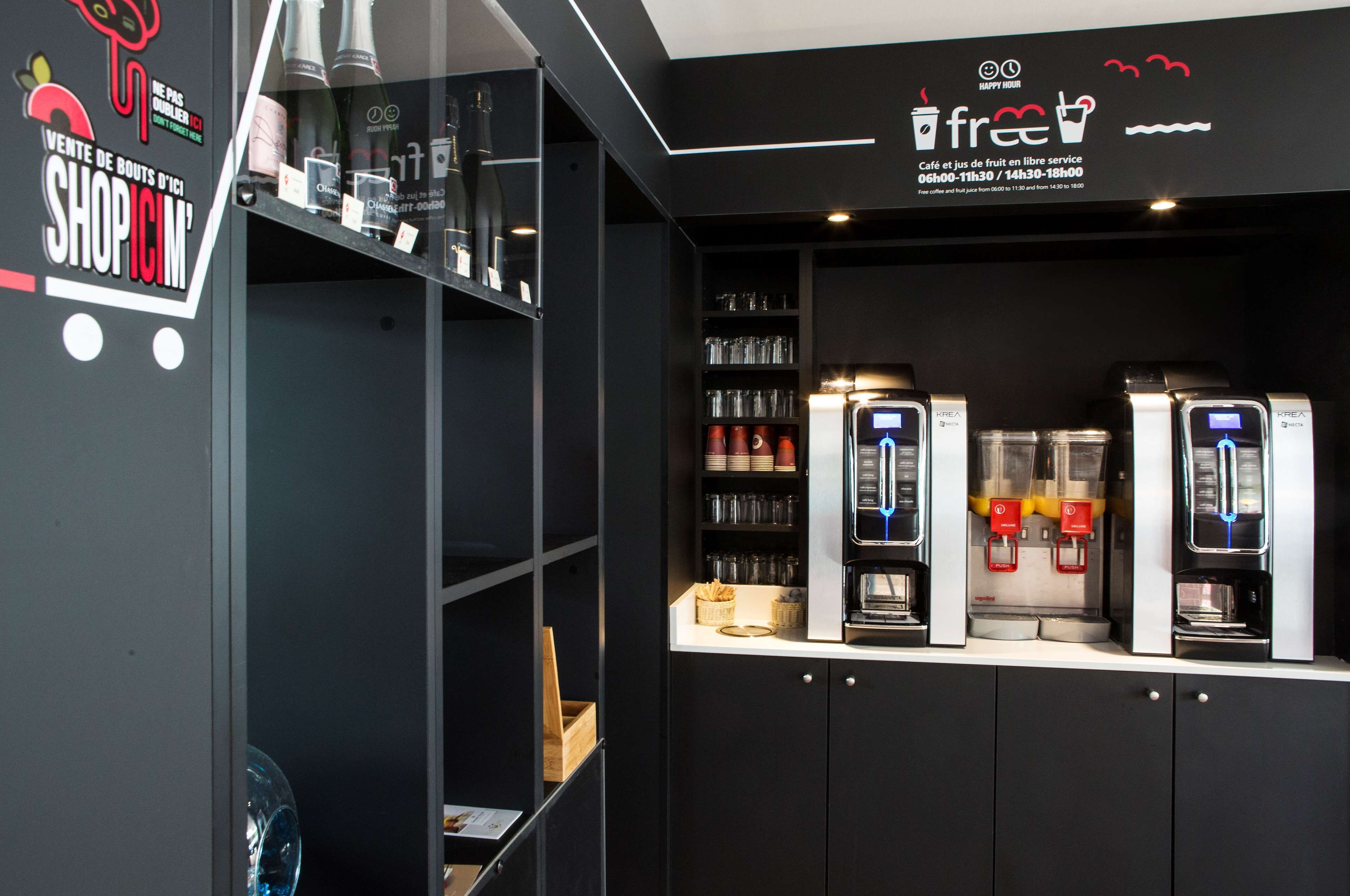 A coffee shop interior with a counter displaying coffee machines, shelves with cups and glasses, and a sign indicating free coffee service hours.