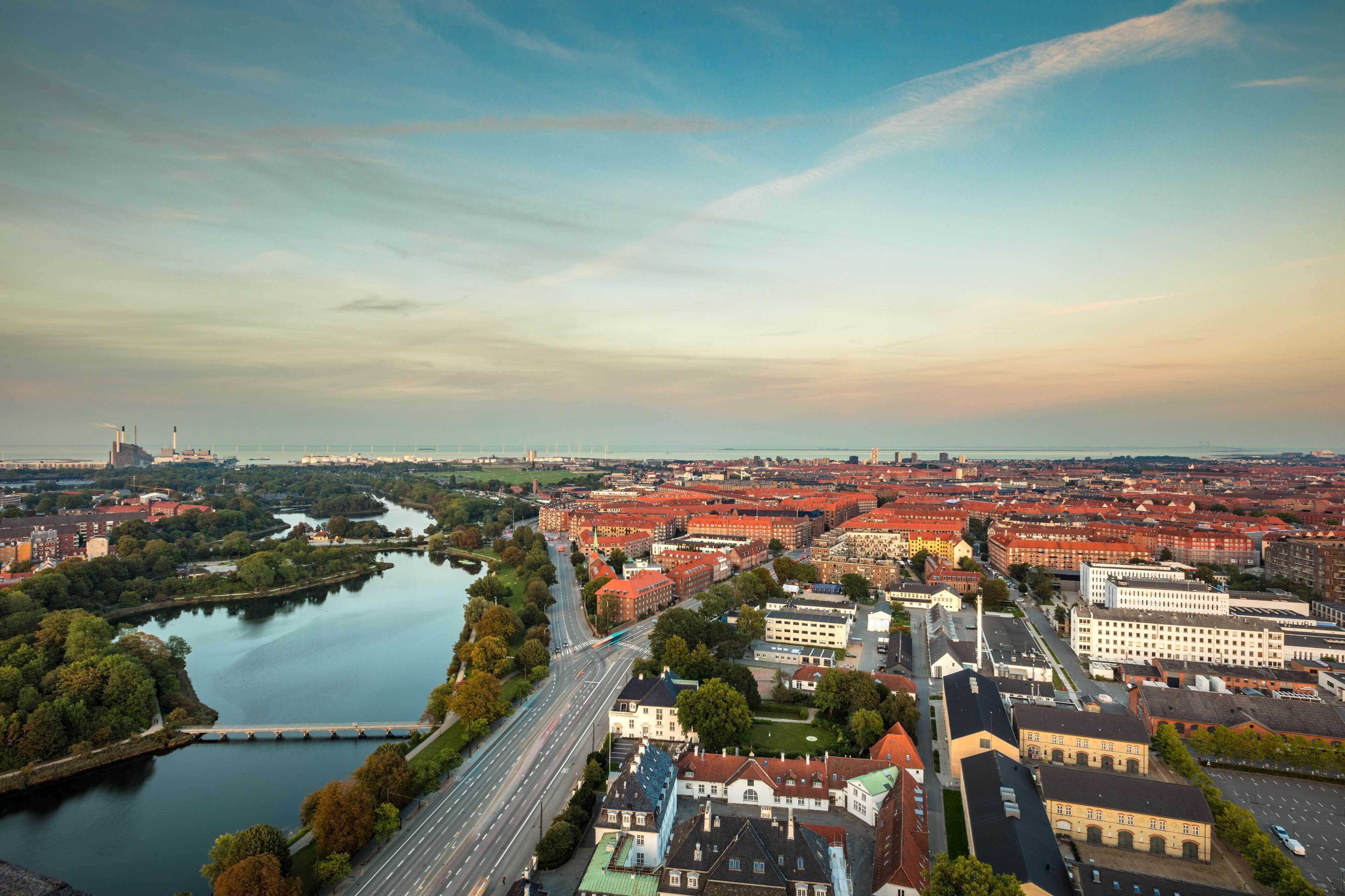 Oversigtsbillede af en by med en flod, broer og en blanding af historiske og moderne bygninger.