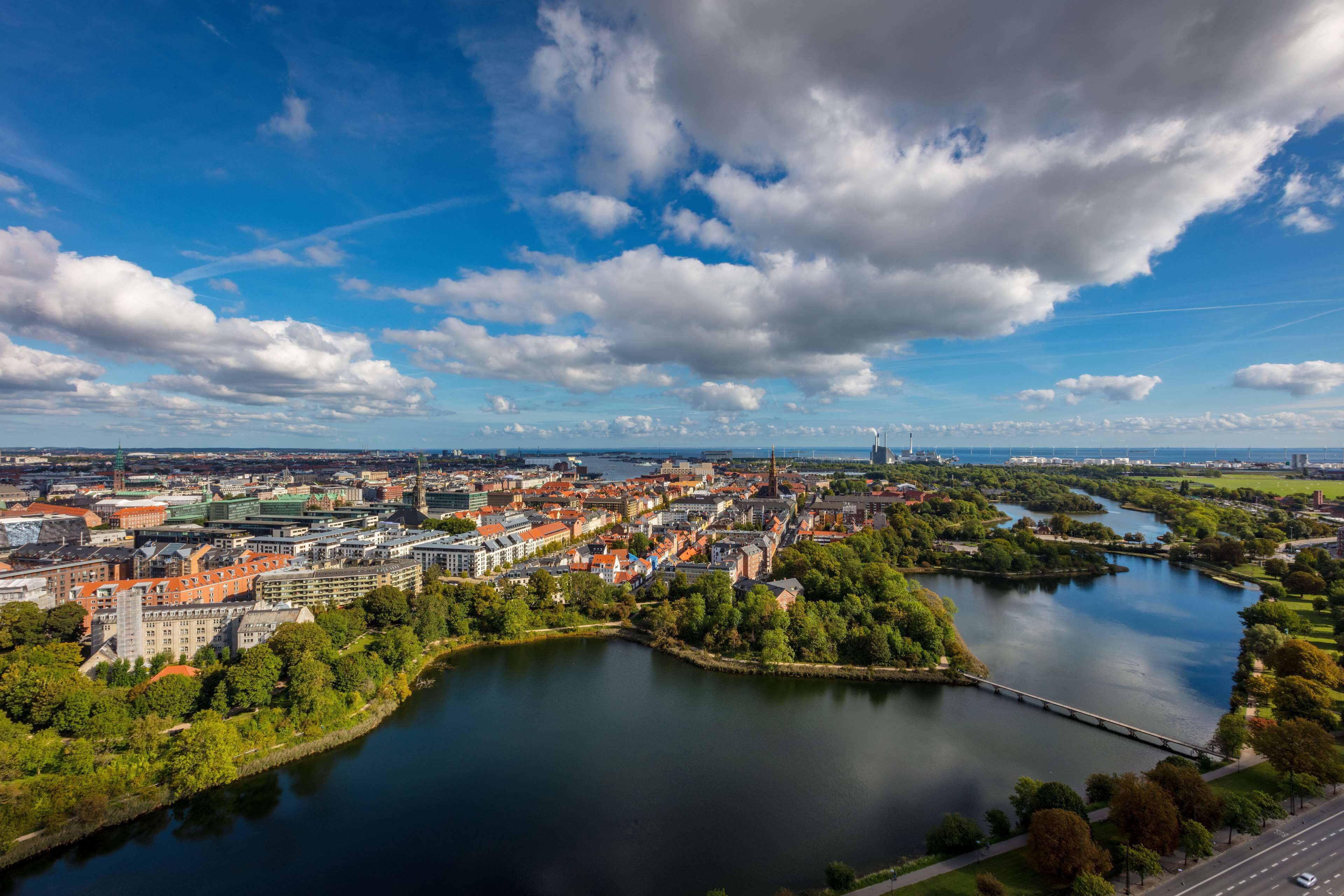 An aerial view of a city with a river, buildings, and a bridge.