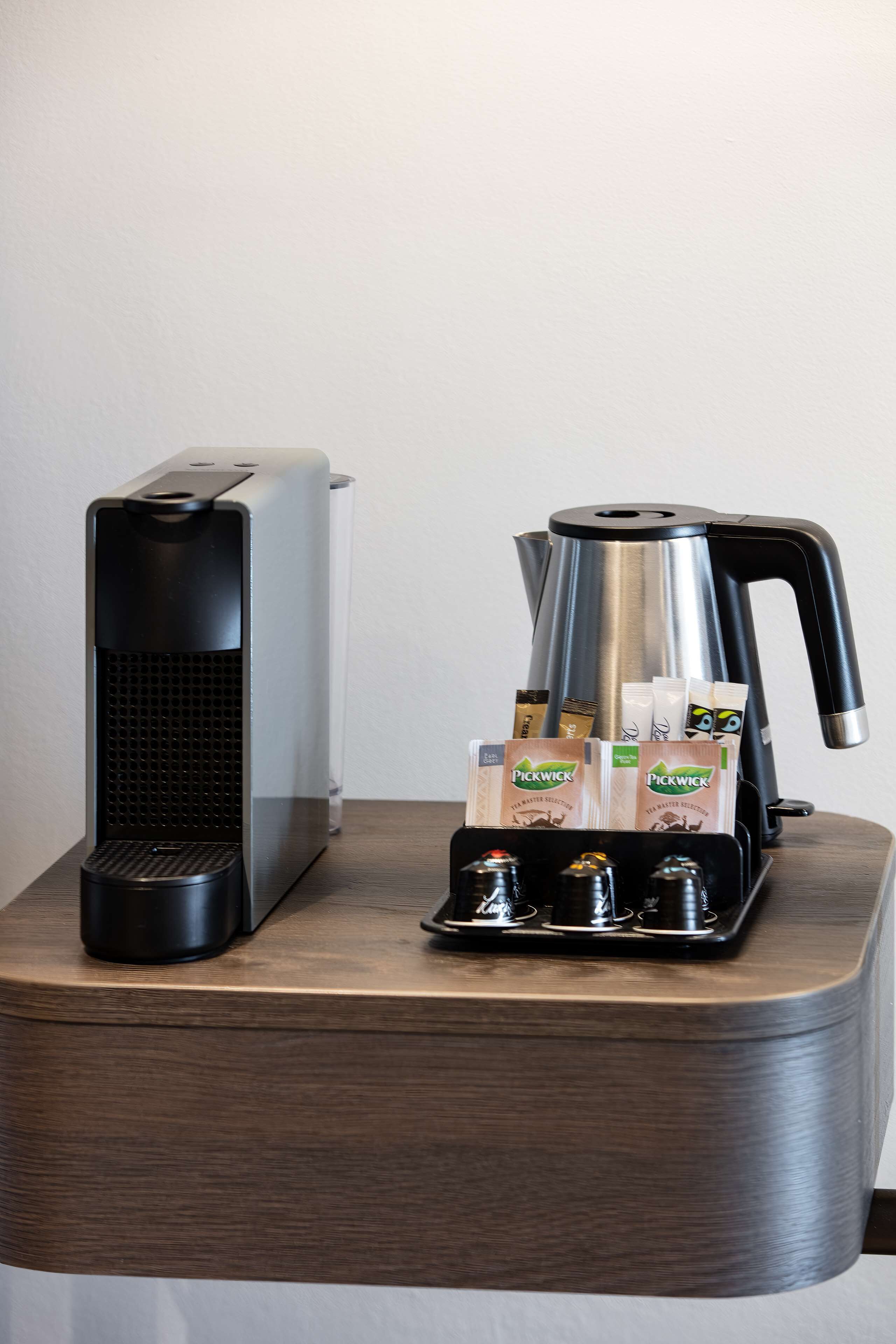 A coffee maker and a coffee pot on a wooden table.