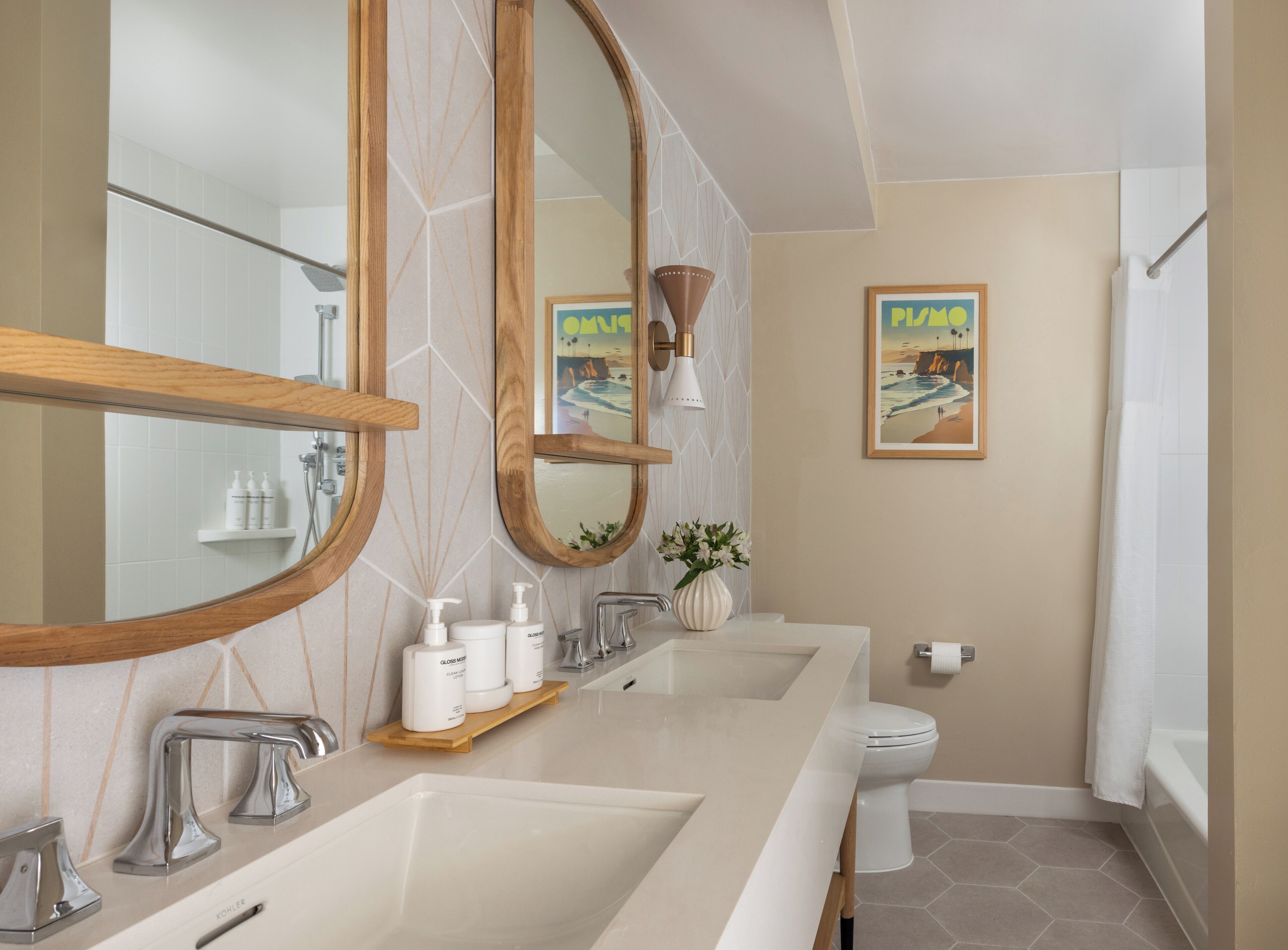 Een moderne badkamer met twee wasbakken, een toilet en een bad.