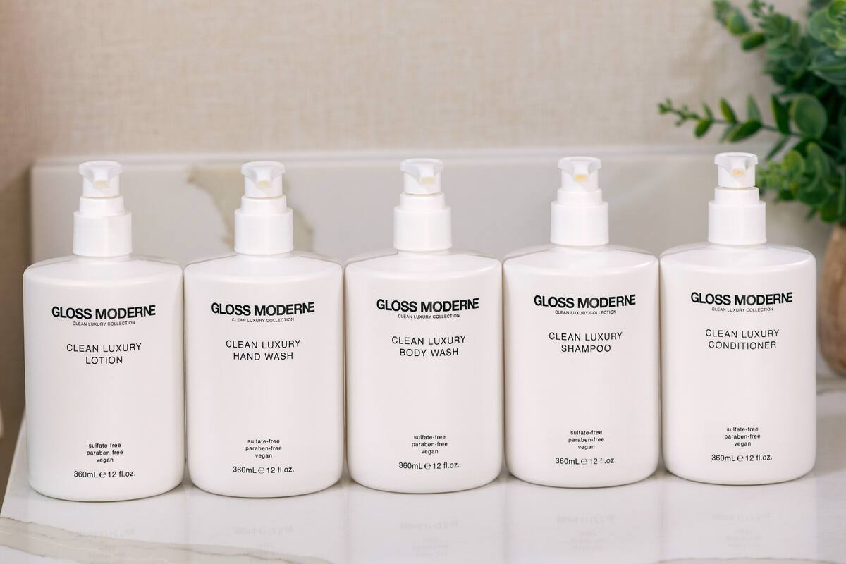 Five white bottles of GLOSS MODERNE products on a white surface.