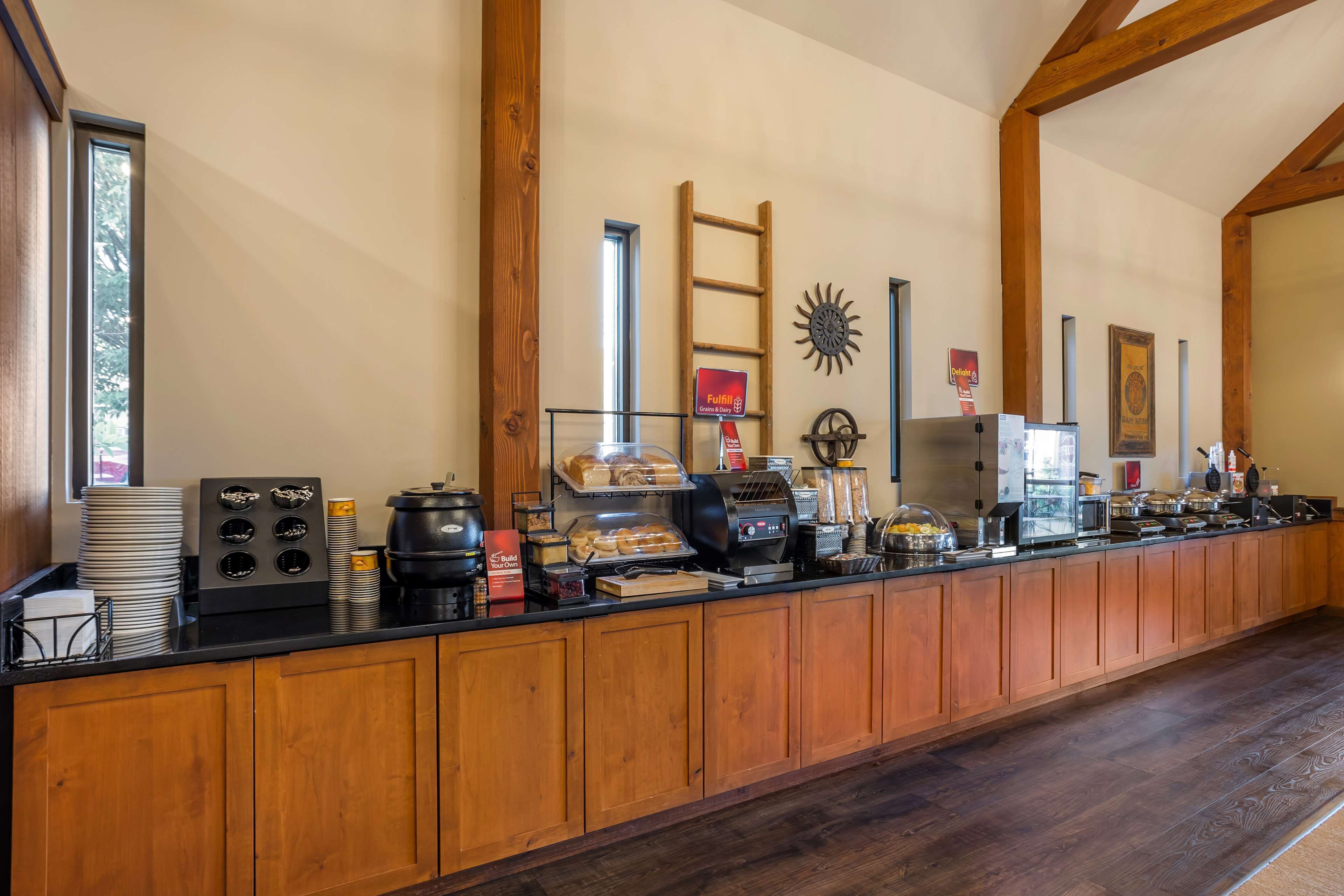 A long buffet counter with wooden cabinets, a coffee station, and various food items.