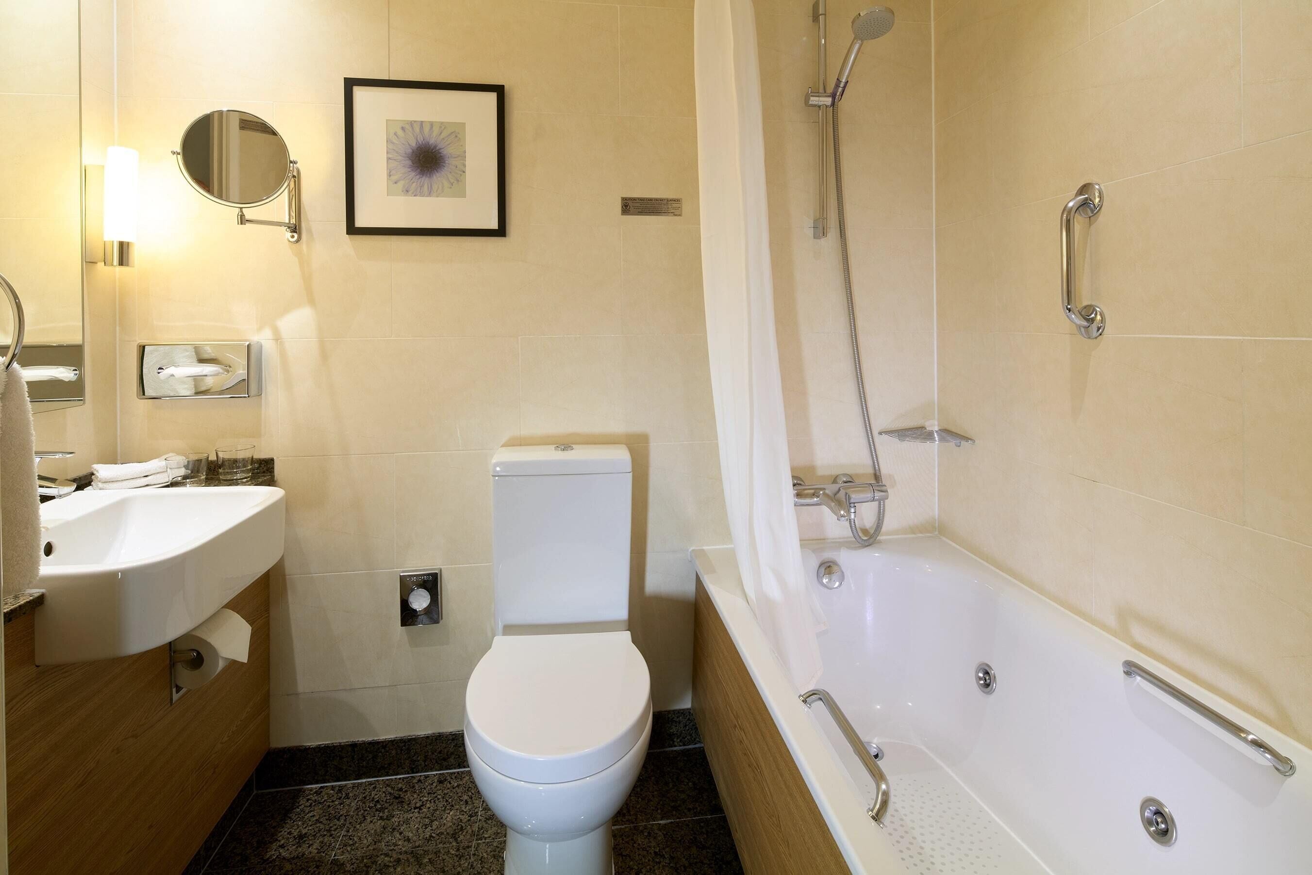 A modern bathroom with a toilet, sink, and bathtub.
