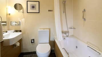 A modern bathroom with a toilet, sink, and bathtub.