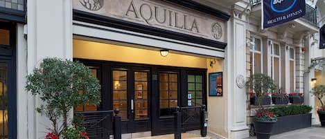 Un edificio con la scritta "AQUILLA" ben visibile sopra l'ingresso.