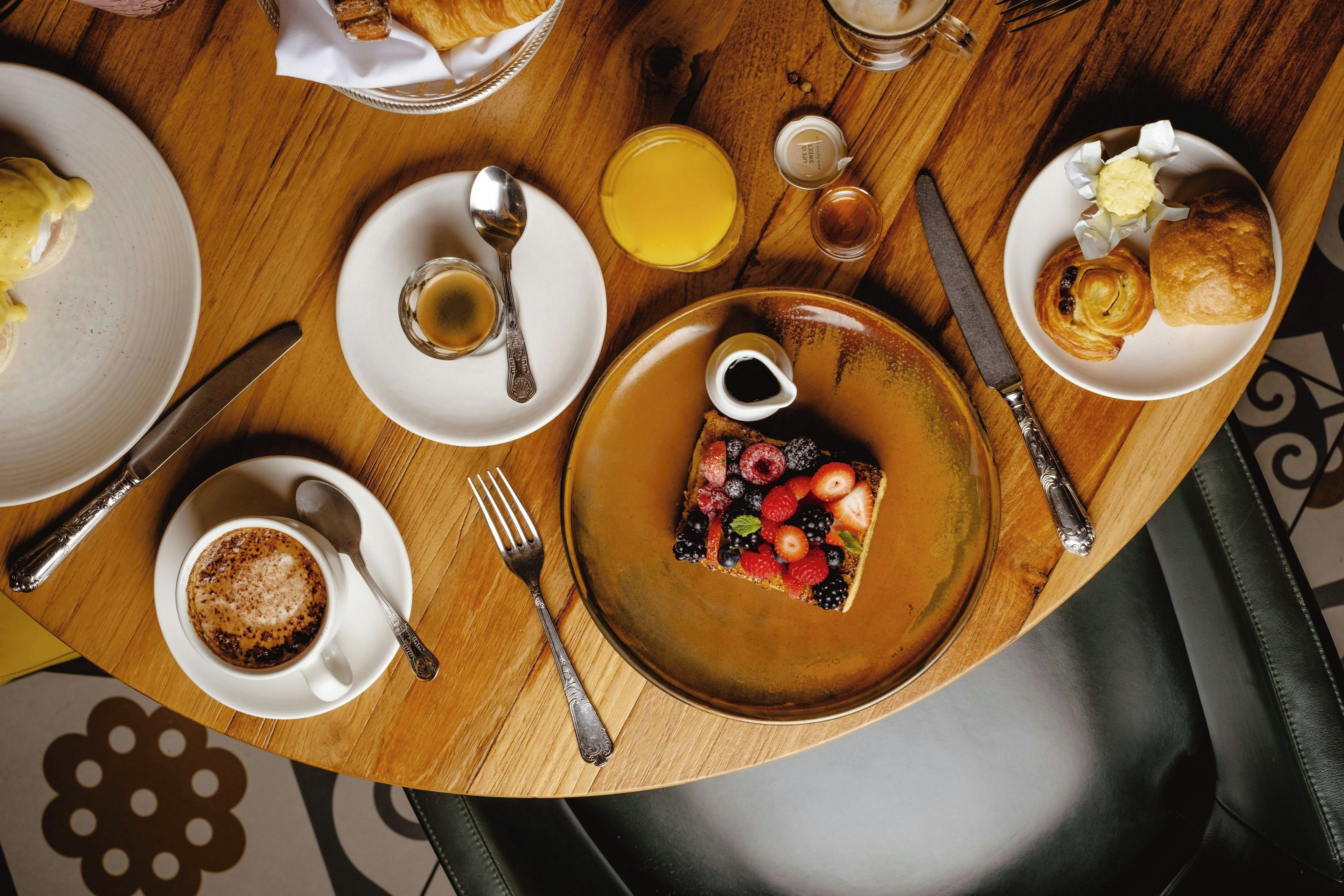 A dining table with various breakfast items including eggs, toast, and fruit.