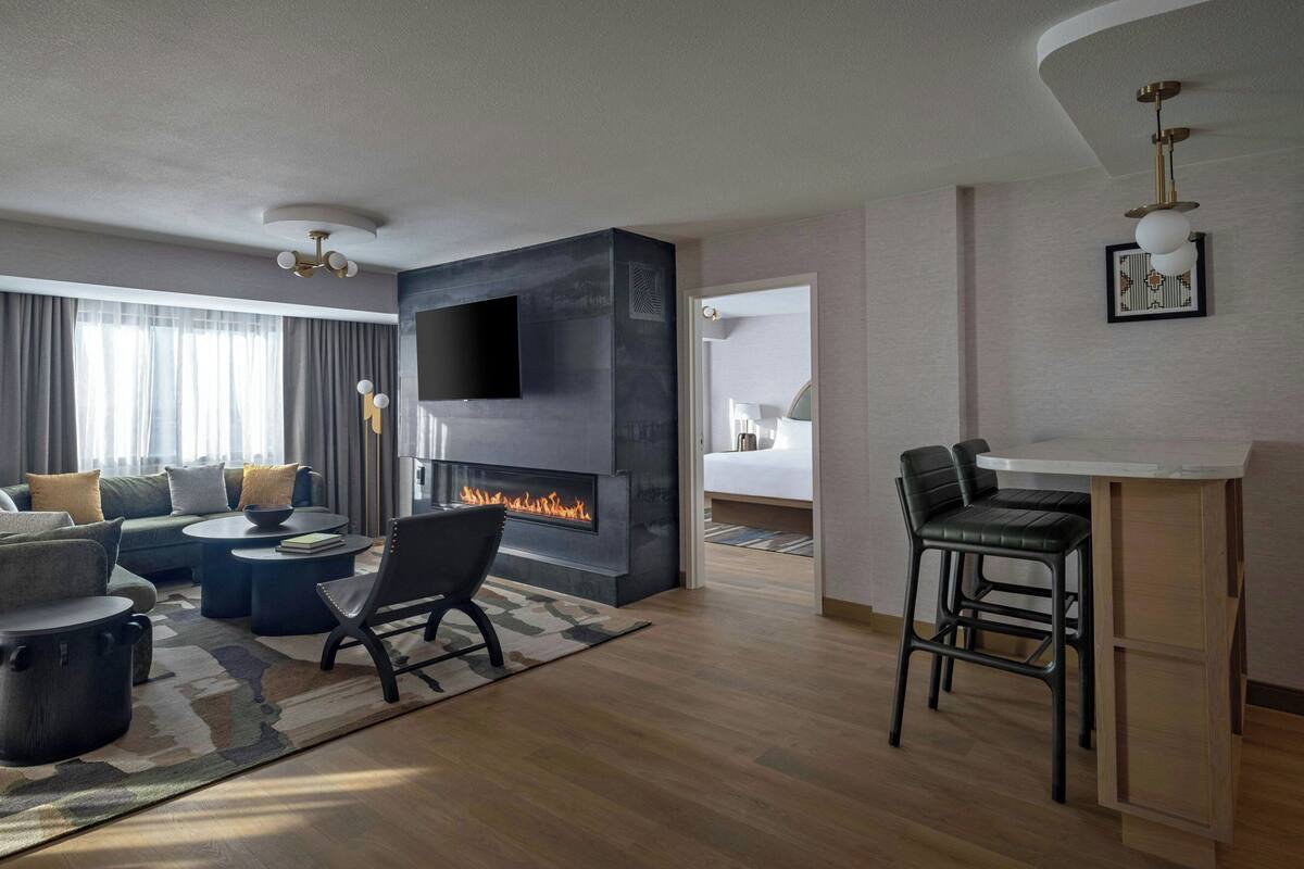 Una sala de estar moderna con chimenea, televisión y zona de bar.