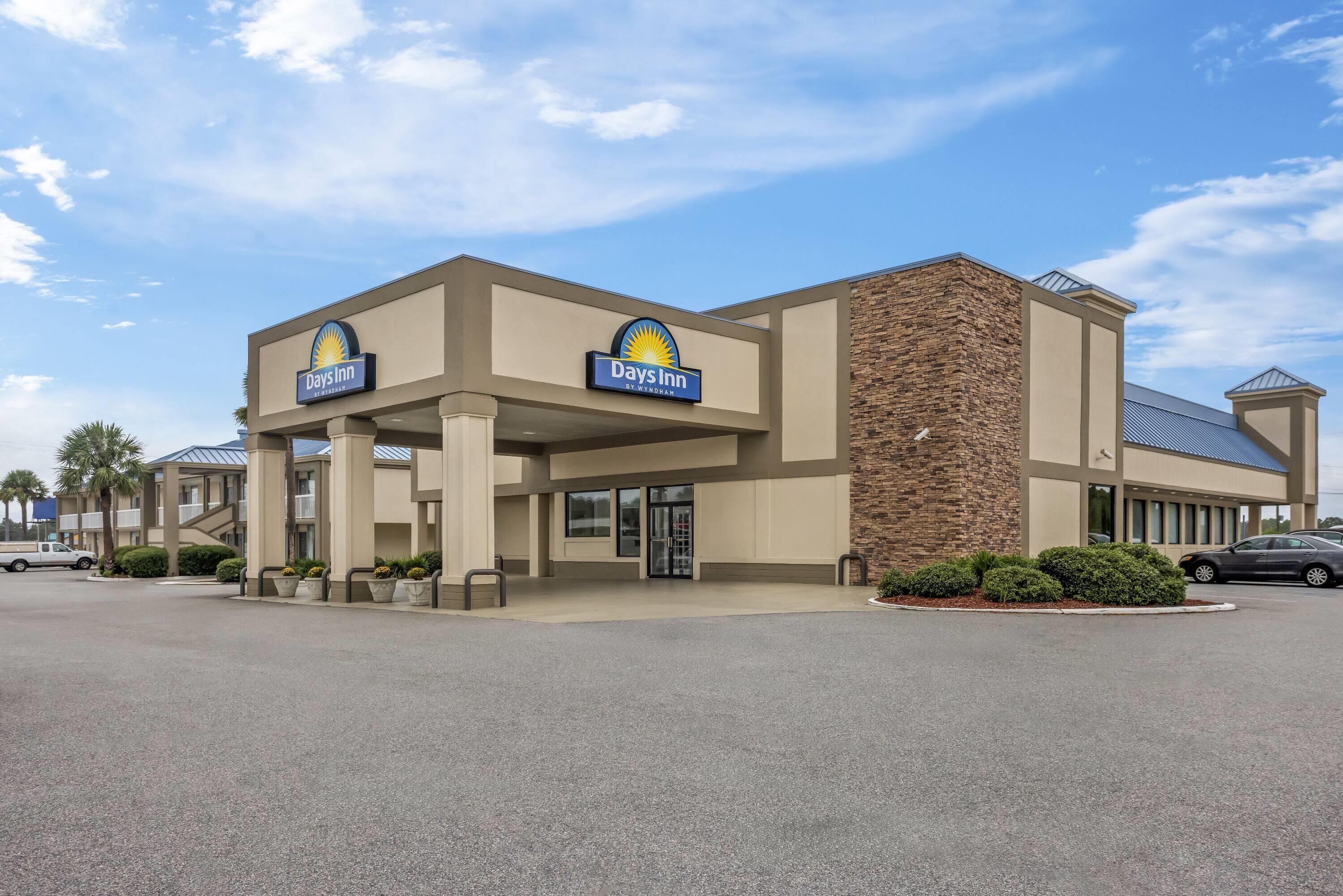 Days Inn -hotelli, jossa on moderni muotoilu, huomiota herättävä sisäänkäynti ja avoin näkymä taivaalle.