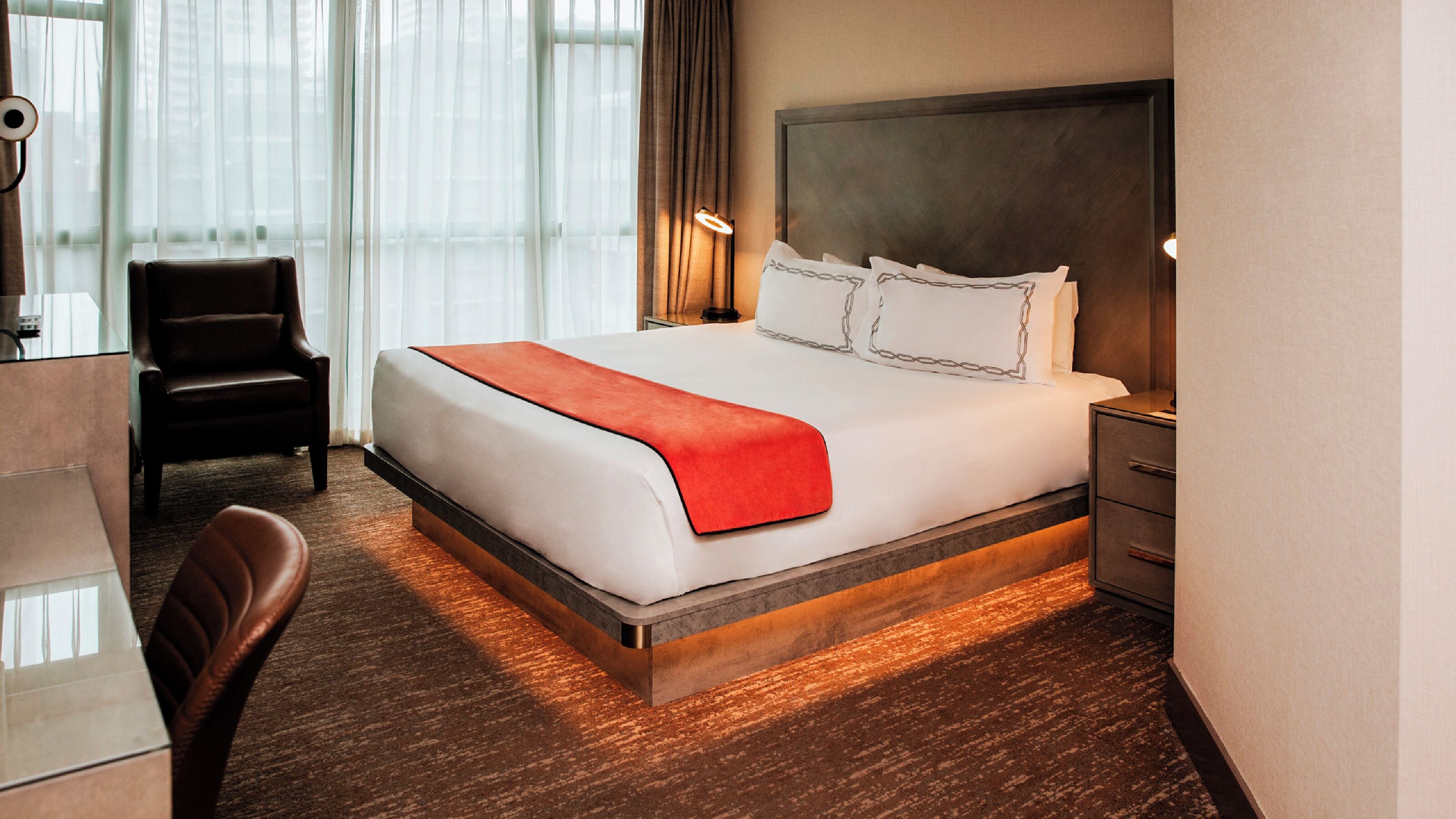 Una habitación de hotel con una cama grande, un escritorio y una silla.