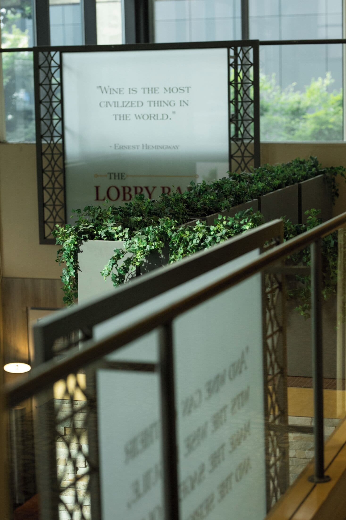 A staircase with a poster reading "Wine is the most civilized thing in the world." by Ernest Hemingway.
