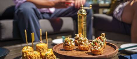 A table with food items, including appetizers and a drink.