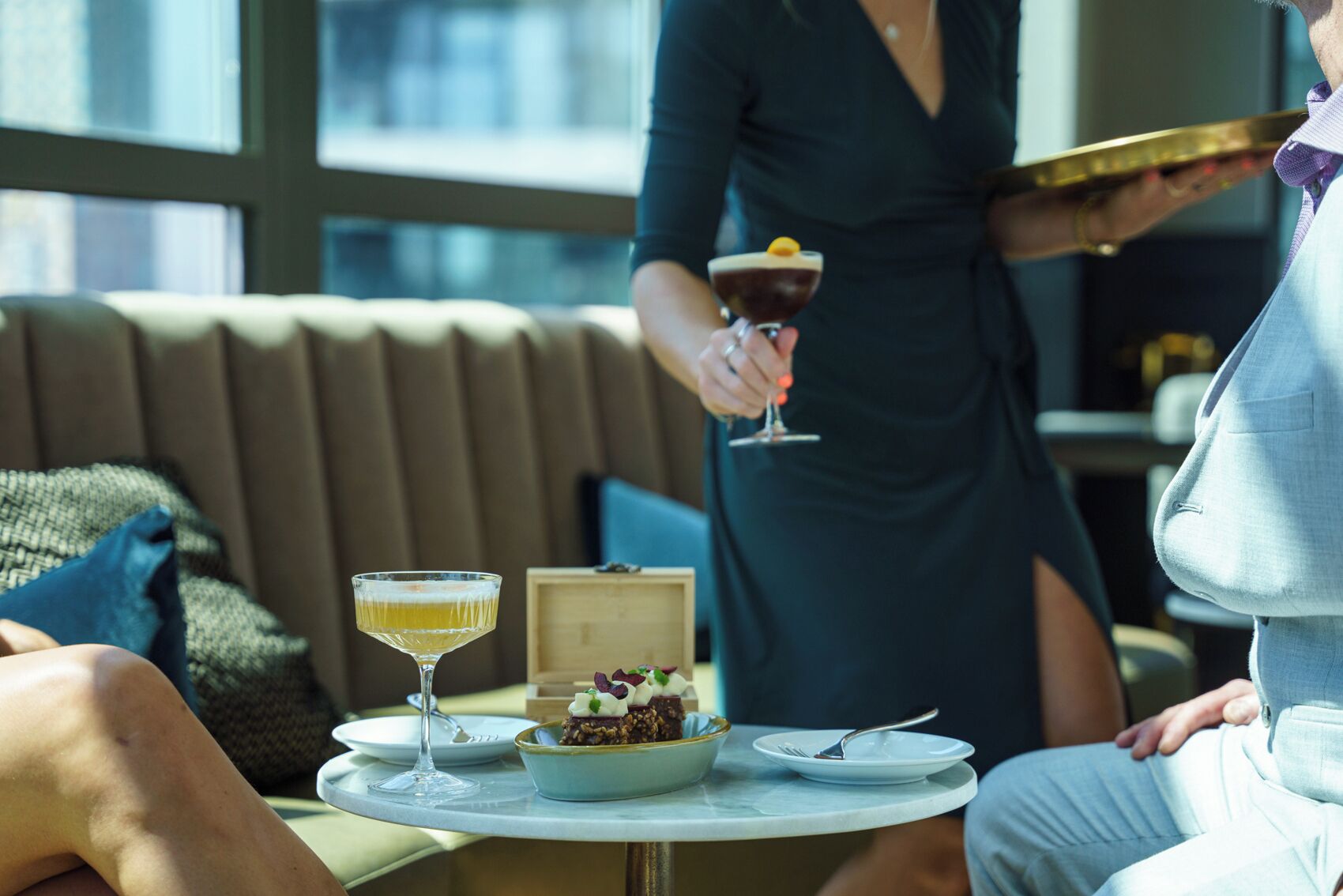 A dining area with a table set for two, a glass of wine, and a dessert.