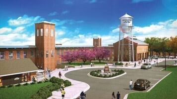 A campus with a central water tower, brick buildings, and a circular plaza with people walking.