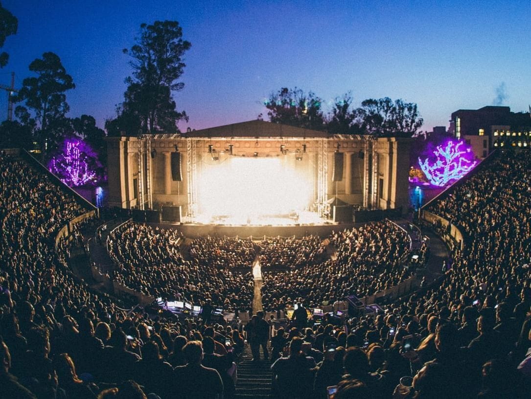 Un vaste amphithéâtre en plein air, doté de gradins et d’une scène à l’avant.