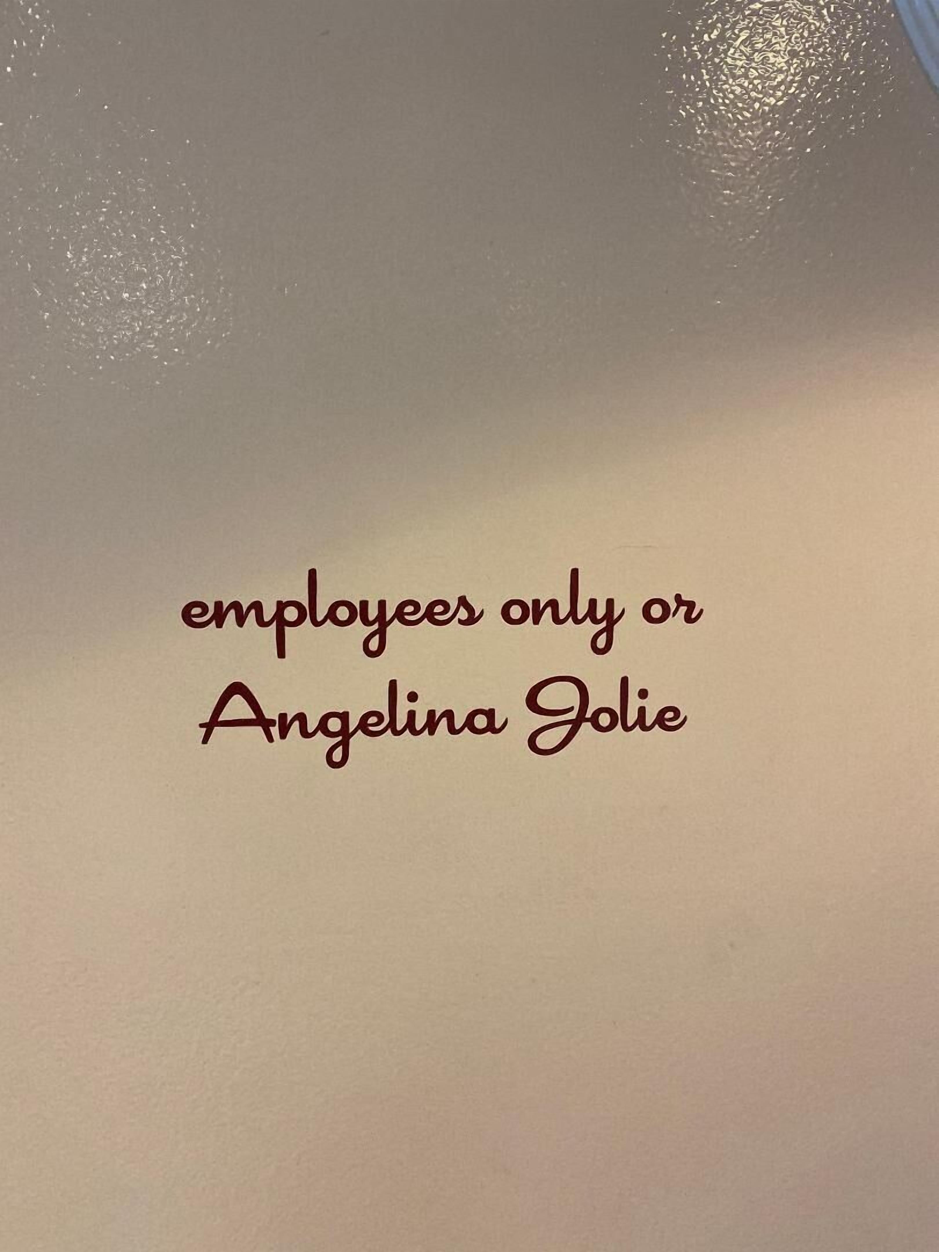 Pared lisa con el texto: 'solo empleados o Angelina Jolie'.