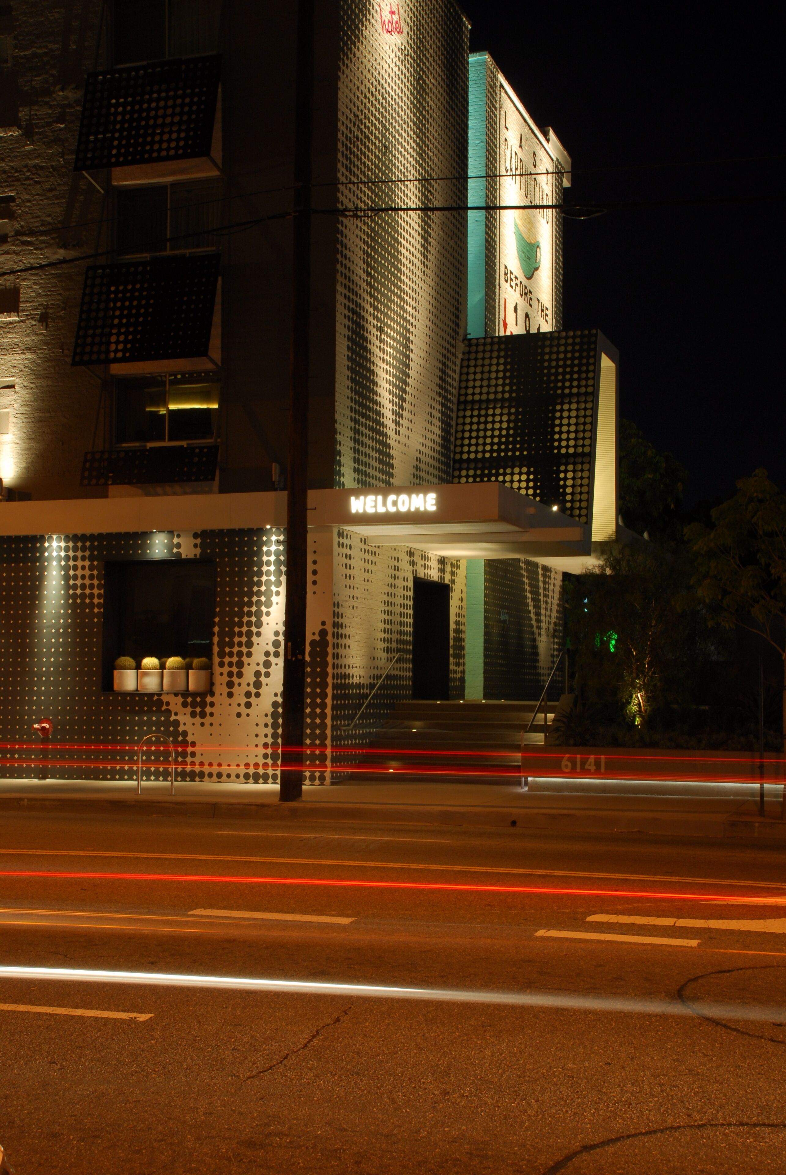A modern building with a 'WELCOME' sign, a patterned facade, and a clear view of the entrance.