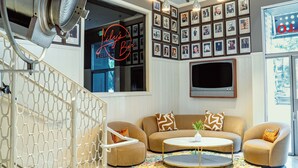 Ein gemütliches Wohnzimmer mit einer Sofagarnitur, einem Couchtisch und einem an der Wand montierten Fernseher.