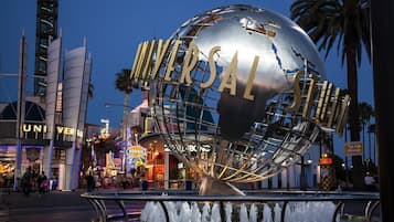 A large metallic globe with "UNIVERSAL" written on it, surrounded by a metal framework, with a water fountain in the foreground.