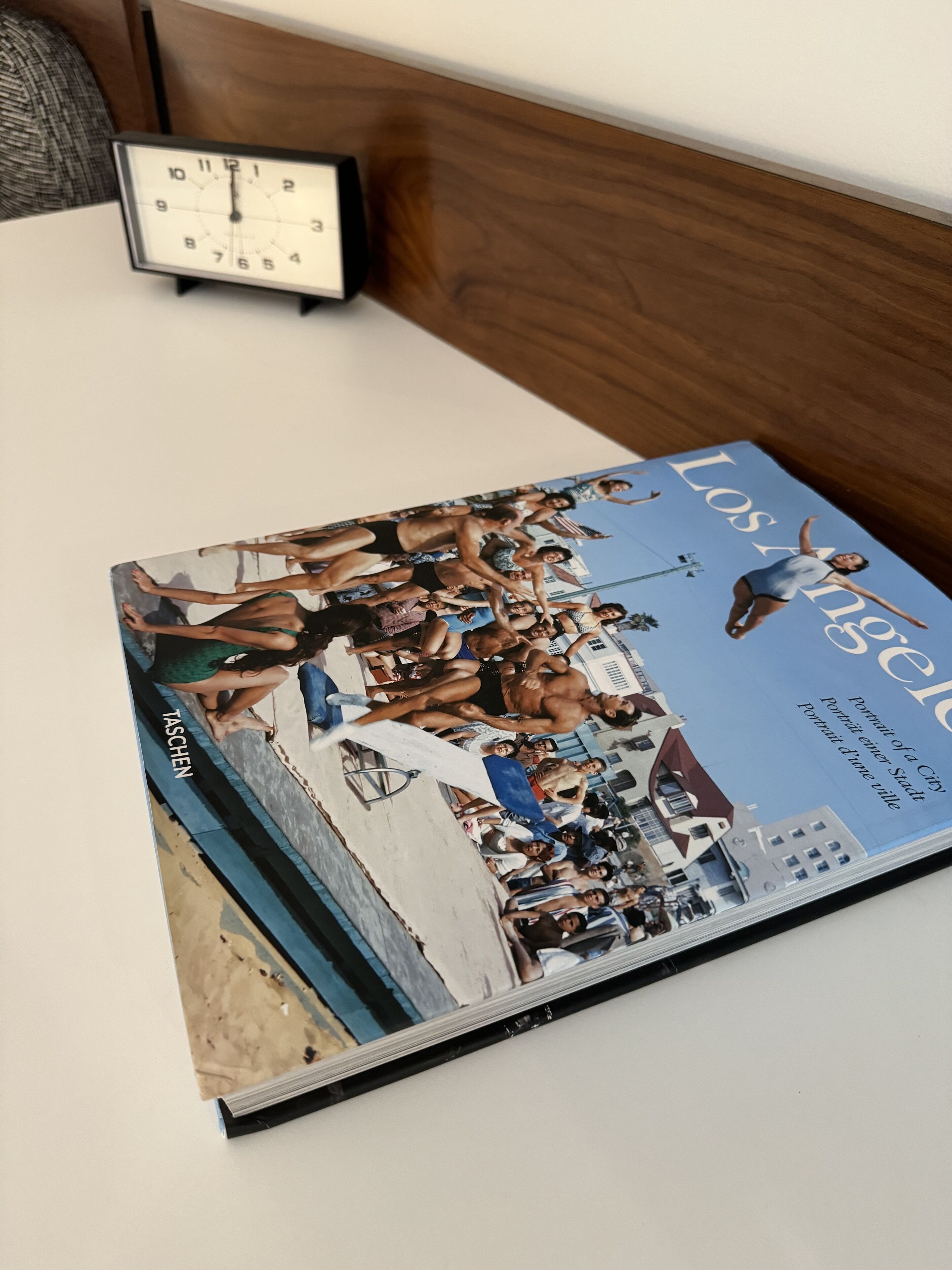 Una revista sobre una mesa, con un reloj al fondo.