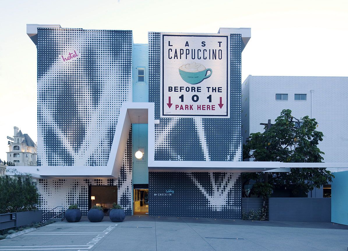 Een modern gebouw met een opvallende geperforeerde gevel en een bord dat de laatste cappuccino aanprijst, vlak voordat je de parkeerplaats 101 bereikt.