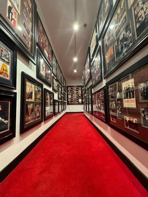 A hallway with framed pictures on the walls and a red carpet. - The Hollywood Franklin Hotel near Universal Studios (Los Angeles)