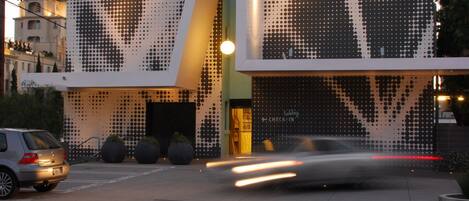 Un bâtiment moderne doté d’une façade originale ornée d’un motif à pois et d’une enseigne bien visible qui fait la publicité du dernier cappuccino servi avant le parking 101.