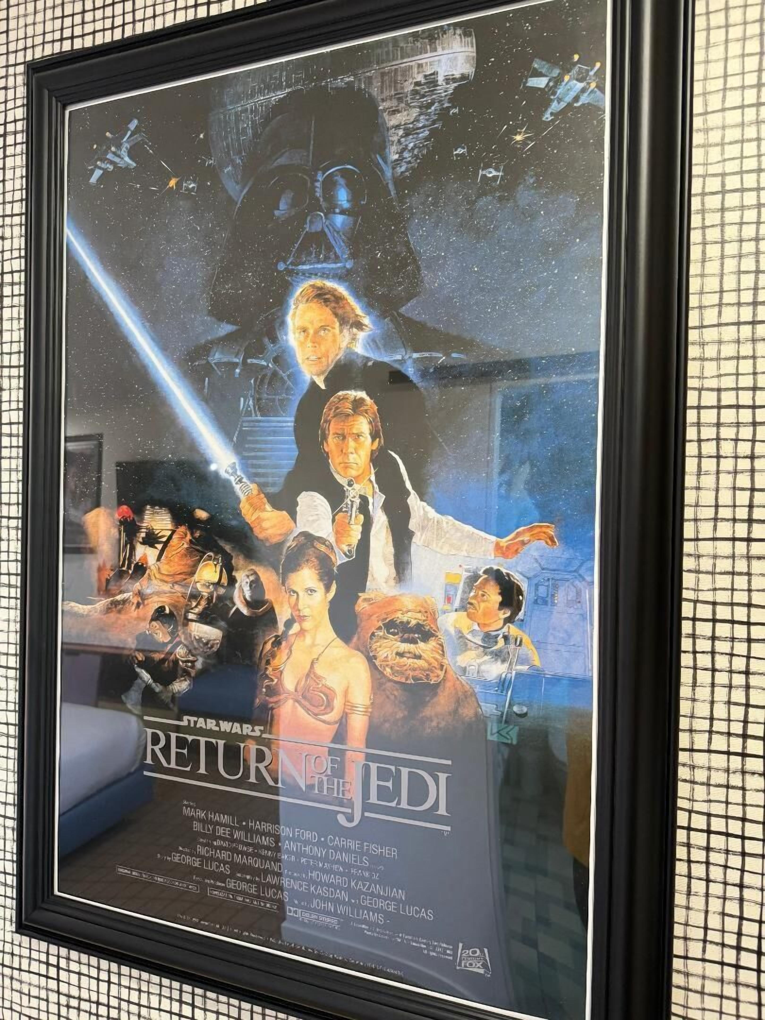 A framed movie poster for 'Star Wars: Return of the Jedi' with a list of cast names and a rating of 20+ by the TCA.