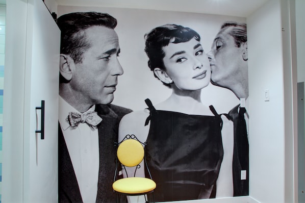 A room with a large poster of a man and woman in formal attire.
