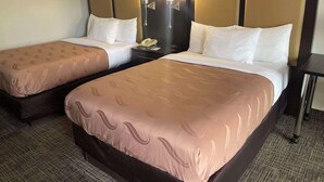 A hotel room with two beds, each with a headboard, a nightstand, and a lamp. - Quality Inn Dalton Central (Dalton)