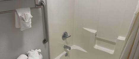 A bathroom with a toilet, a towel rack, and a bathtub.
