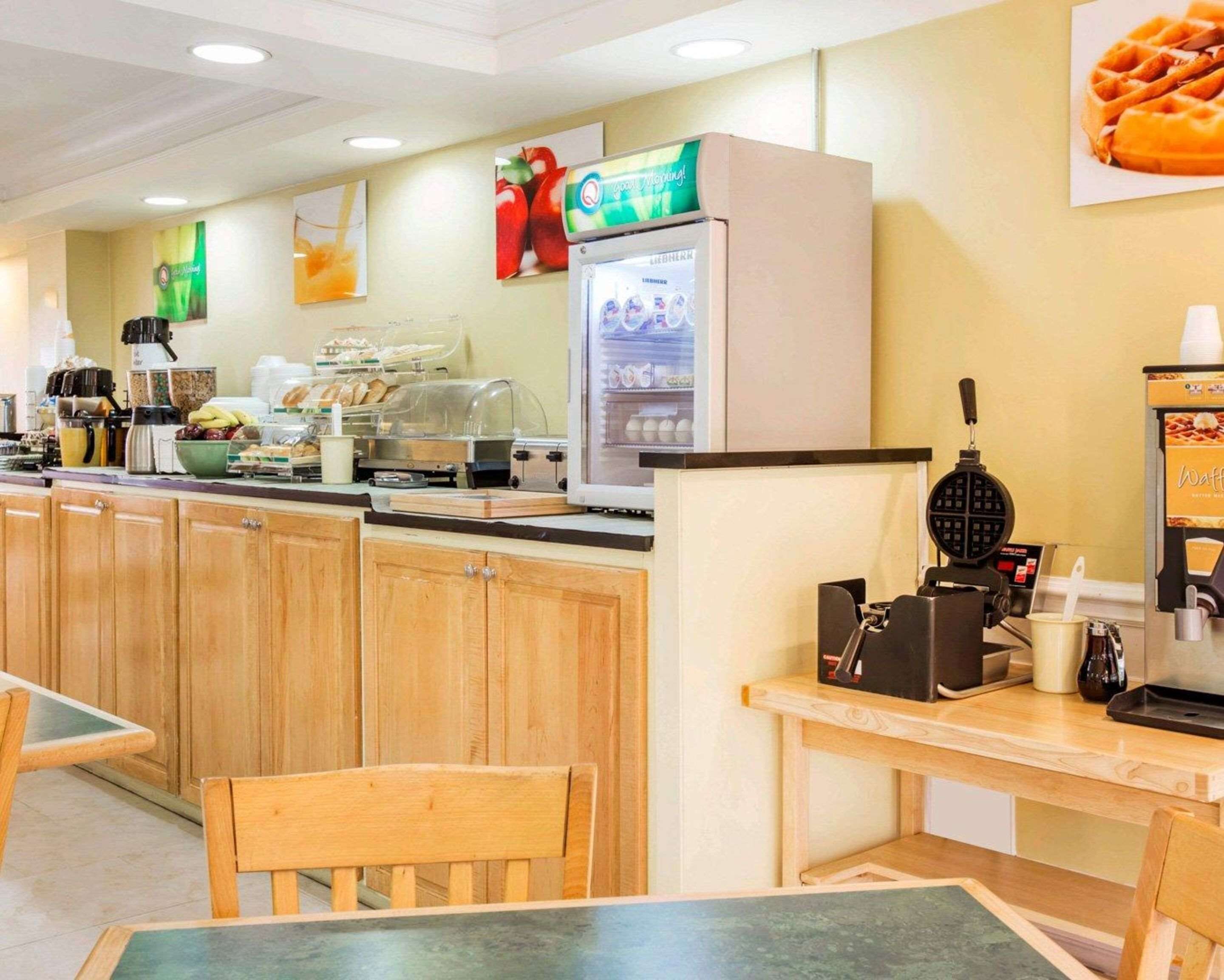 A breakfast area with wooden cabinets, a coffee machine, a waffle maker, and a refrigerator.