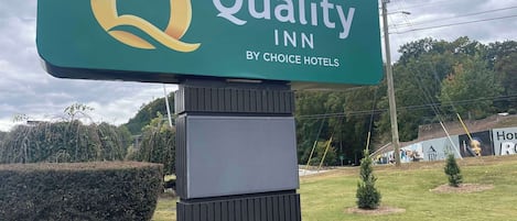 Une grande enseigne pour le Quality Inn, un hôtel du groupe Choice Hotels, avec son logo et son nom.