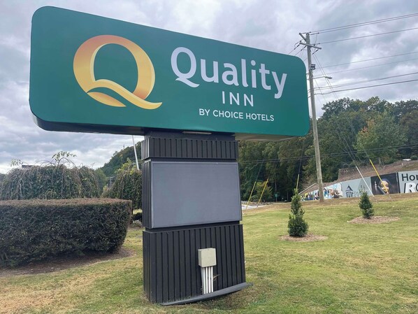 Uma placa grande para Quality Inn by Choice Hotels, com logotipo e nome.