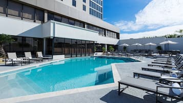 Relax by the pool surrounded by comfortable sun loungers and umbrellas.