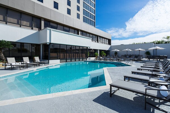 A modern hotel with a swimming pool, sun loungers, and umbrellas. - Marriott Baton Rouge (Baton Rouge)