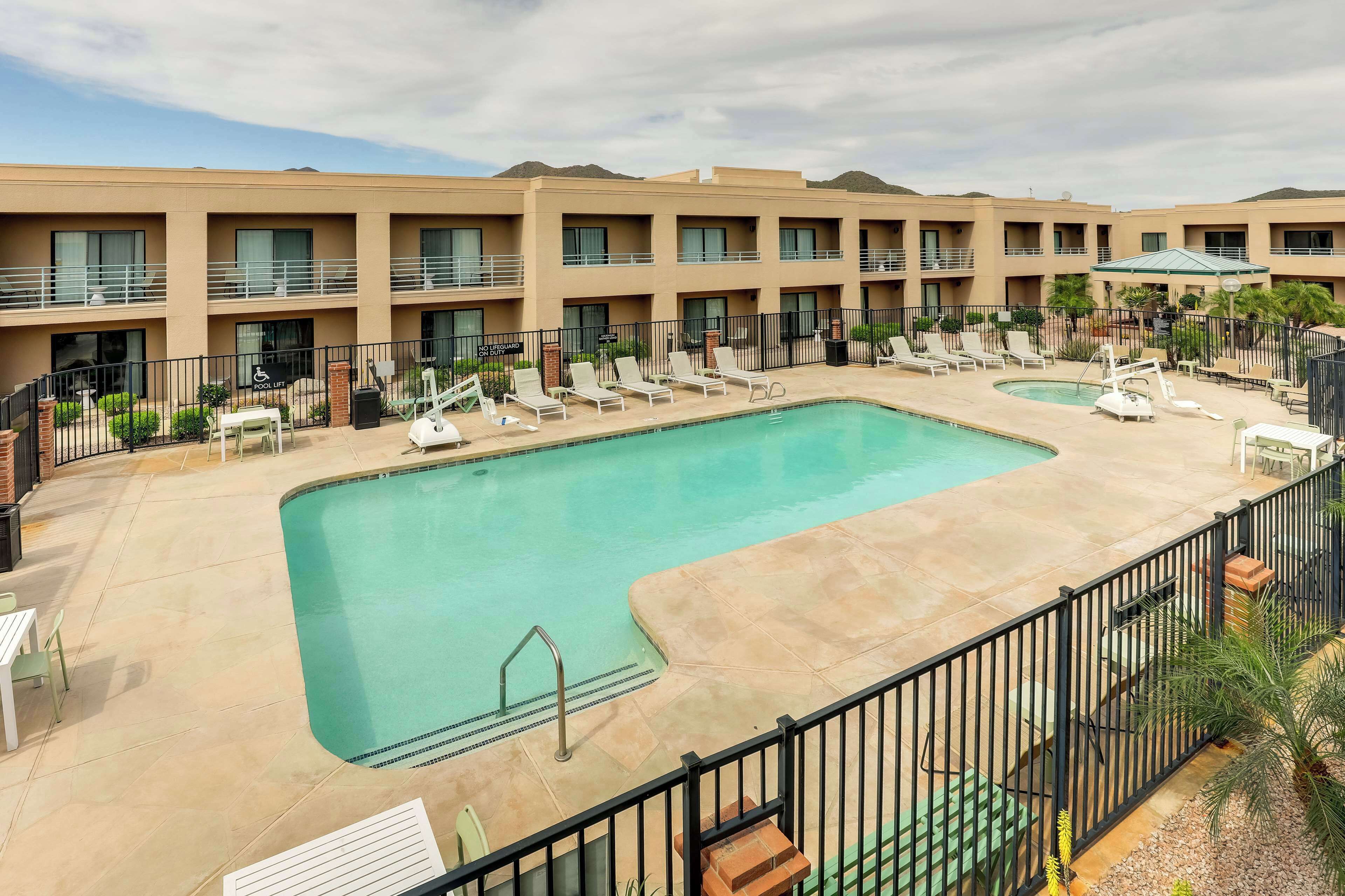 Un hotel con area piscina, diversi balconi e cielo sereno.