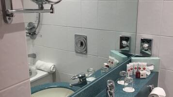 Un baño con dos lavamanos, un espejo y artículos de aseo.