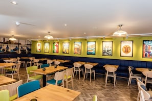 A restaurant interior with booths, tables, and chairs. - Holiday Inn Dover by IHG (Dover)