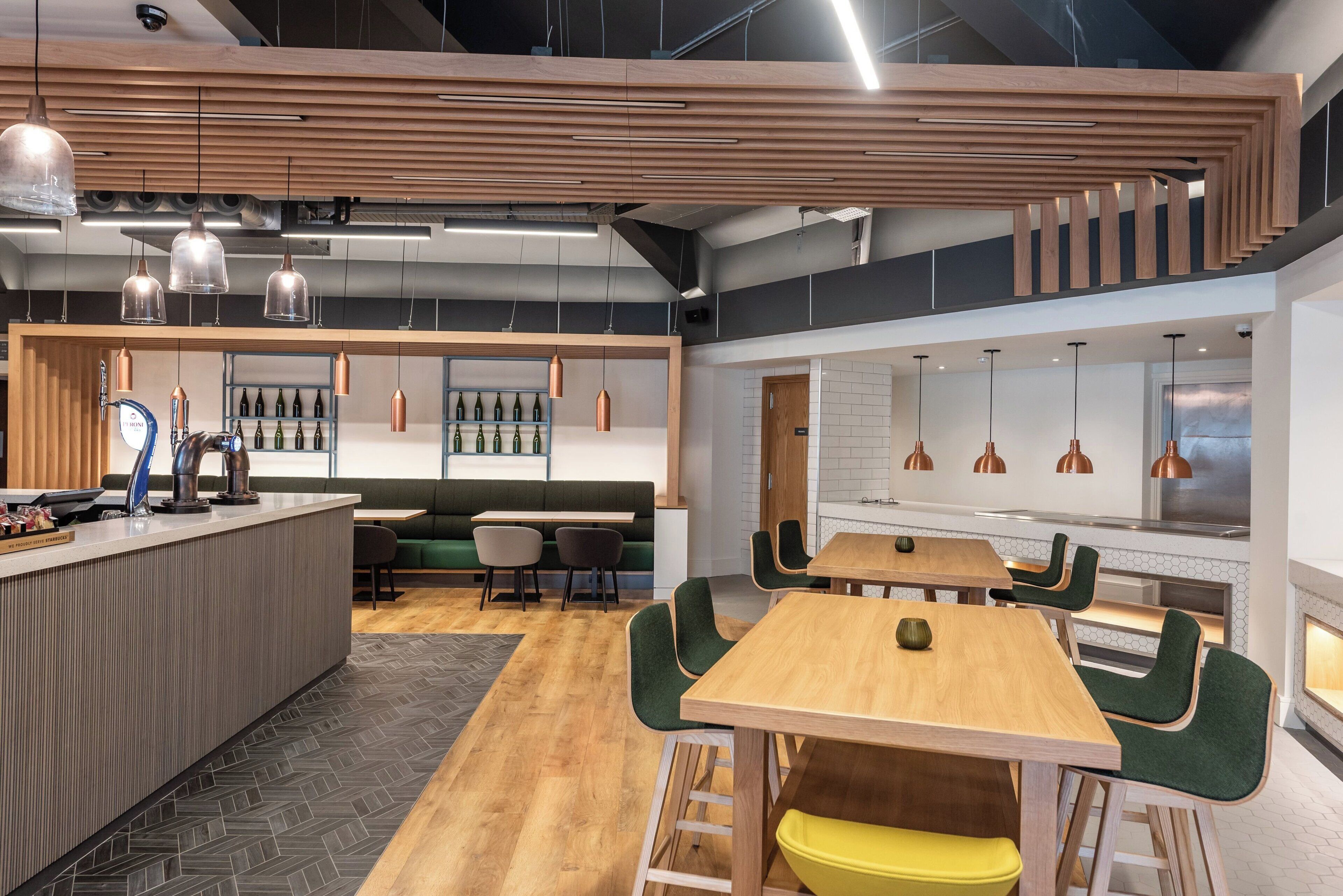 A modern interior with a bar area, seating, and a staircase.