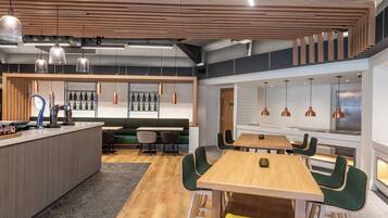 A modern interior with a bar area, seating, and a staircase.