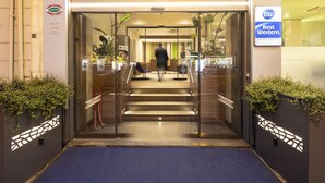 A hotel entrance with a glass door, a blue carpet, and a Best Western sign. - Best Western Hotel Luxor (Turin)