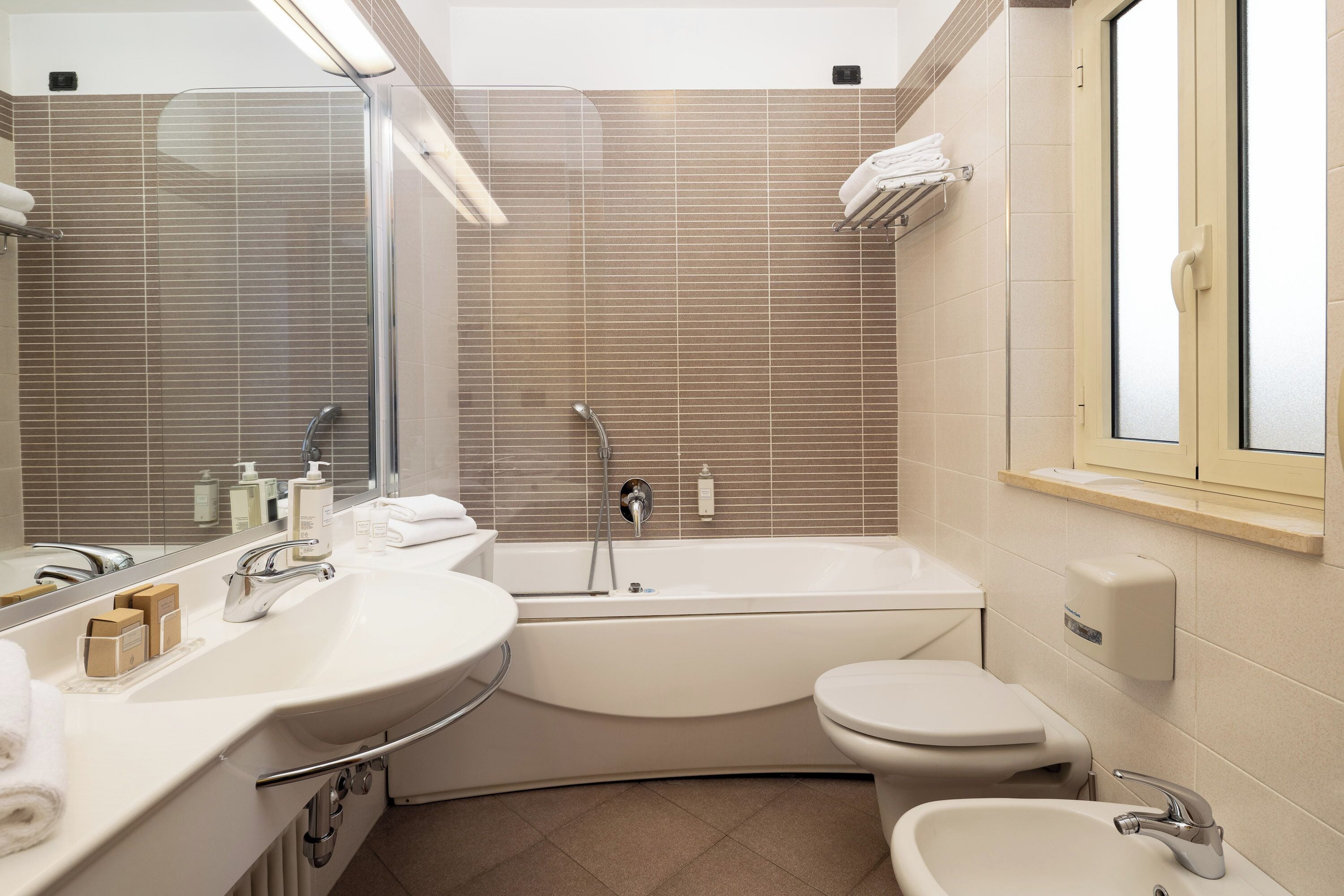 A modern bathroom with a bathtub, toilet, and sink.