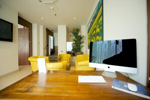Un espace de bureau moderne comprenant un bureau en bois, un écran d’ordinateur, un clavier et une chaise.
