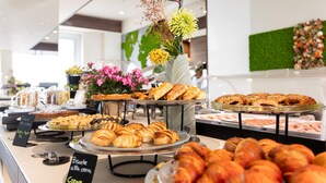 A buffet with various pastries and desserts, including croissants and cakes, displayed on multiple serving trays. - Best Western Hotel Luxor (Turin)
