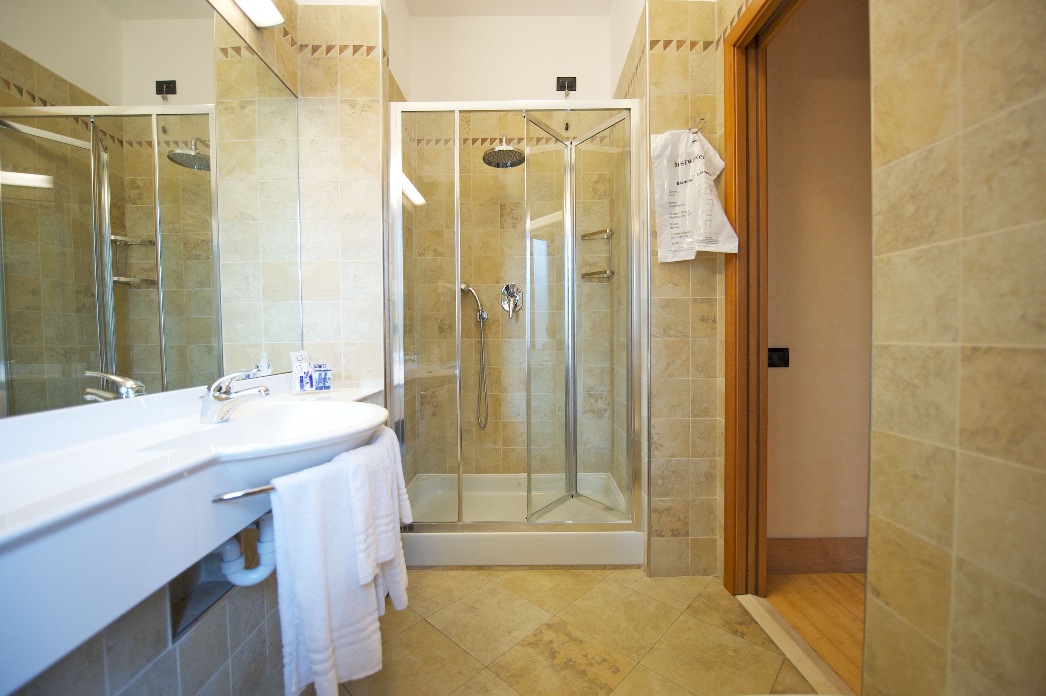 A modern bathroom with a glass-enclosed shower, a white sink, and a mirror.