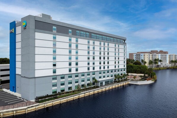 Un hotel moderno con muchas habitaciones, estacionamiento y vista al agua.