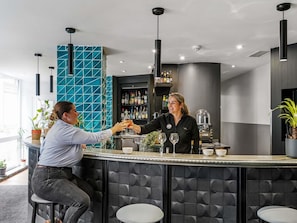 Ein Bartresn mit modernem Design, ausgestattet mit einer Theke, Hockern und einer Flaschenregal.