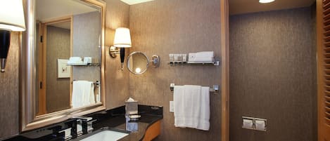 Un baño moderno con un espejo grande, un lavabo, un inodoro y una zona de ducha.