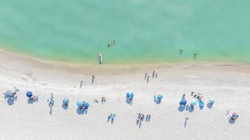 On the beach, white sand, sun loungers, beach umbrellas